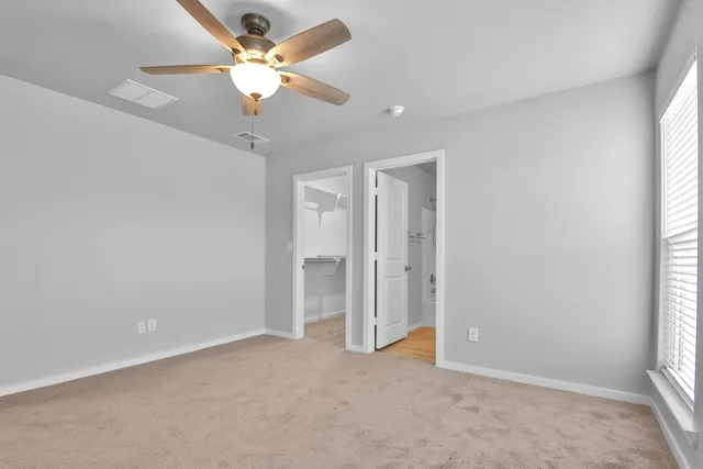 an empty room with fan and windows