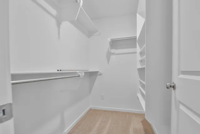 a view of walk in closet with empty racks