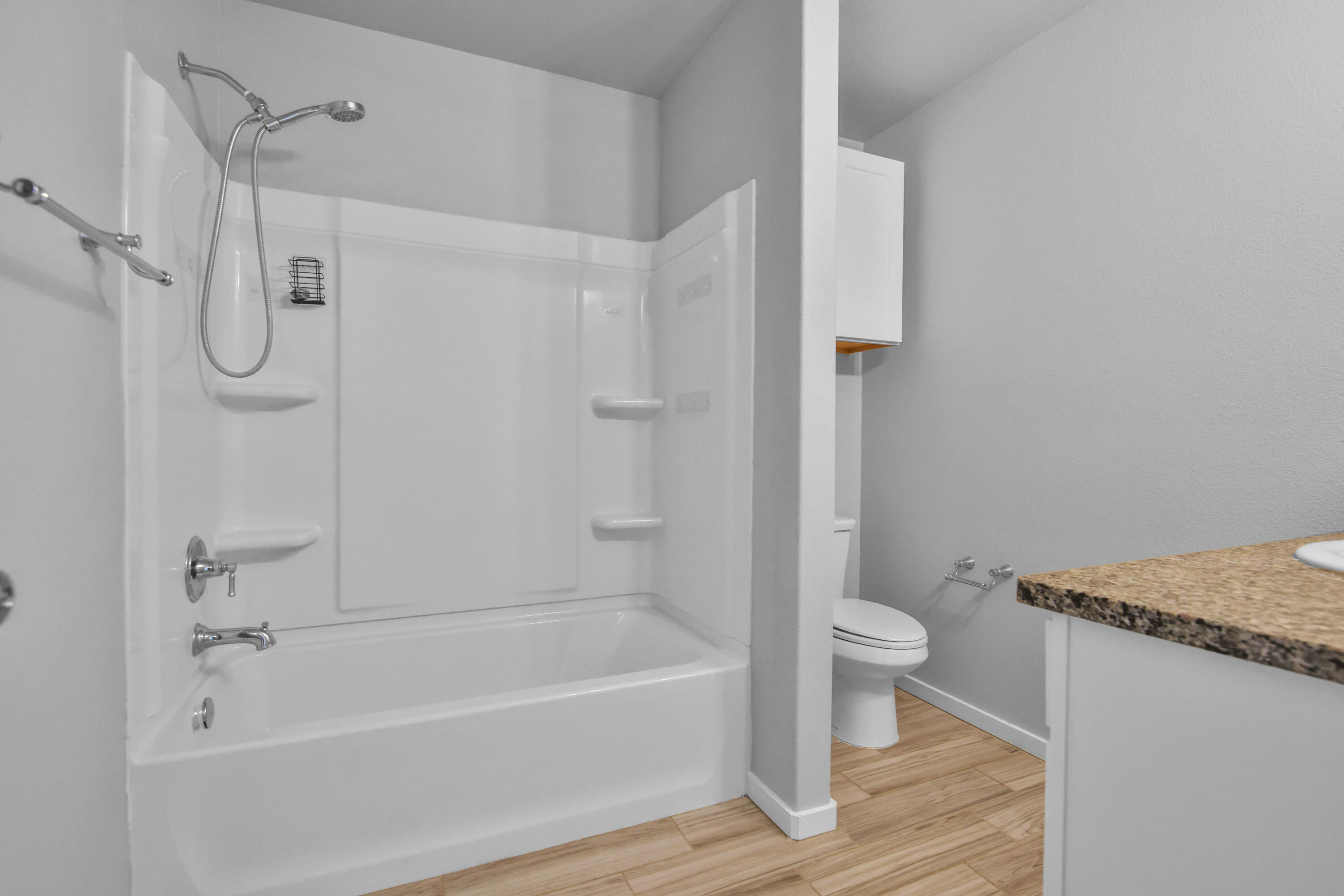 7526 104th Street Lubbock, TX 79424 - Photo 15 of 28 a bathroom with a granite countertop bathtub shower and toilet