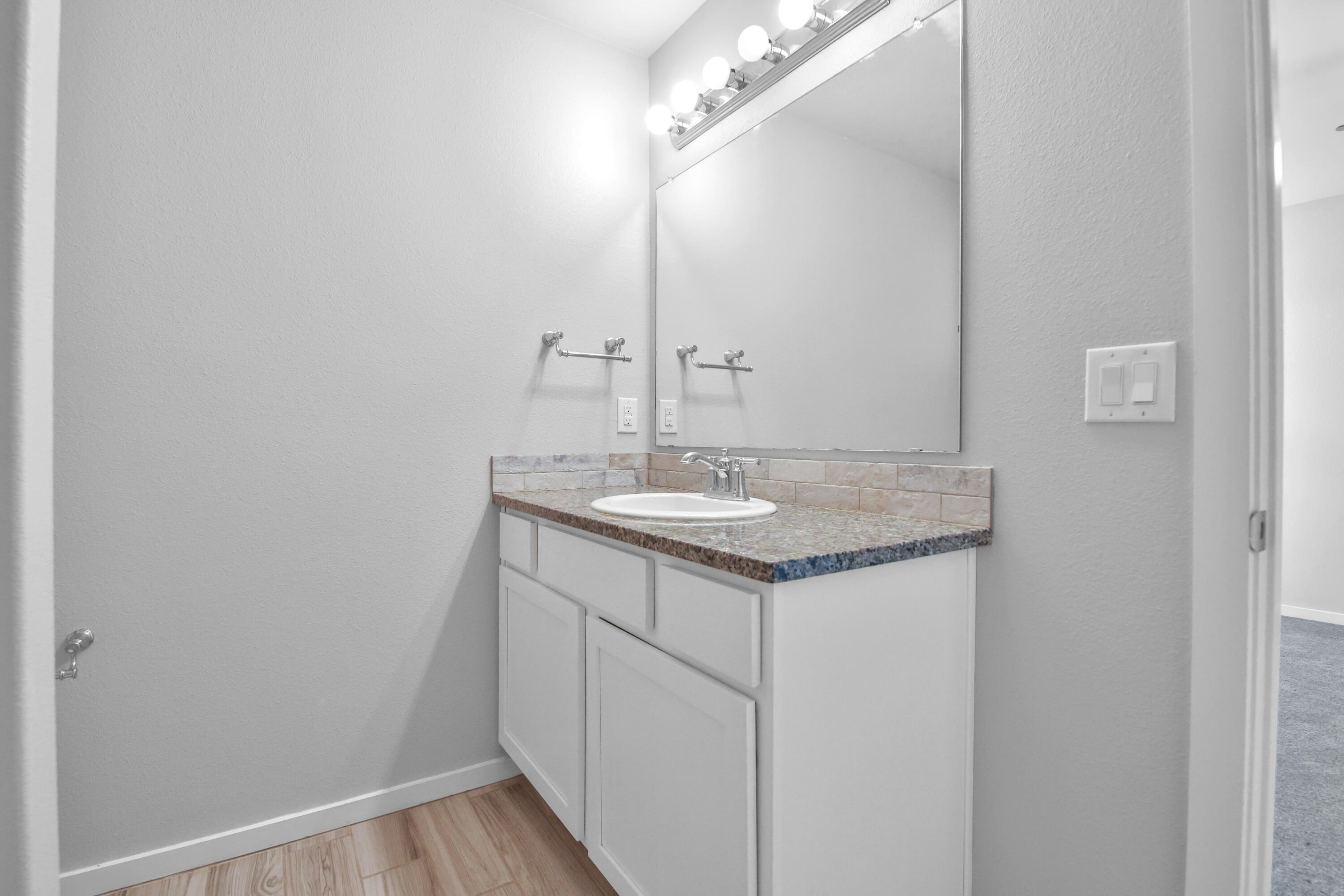 7526 104th Street Lubbock, TX 79424 - Photo 16 of 28 a bathroom with a sink vanity and a mirror