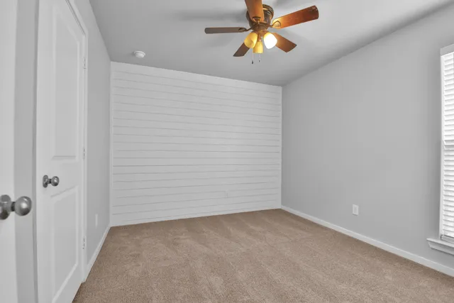 an empty room with a chandelier fan and a chandelier fan