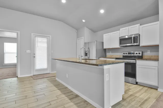 a kitchen with stainless steel appliances granite countertop a sink and cabinets
