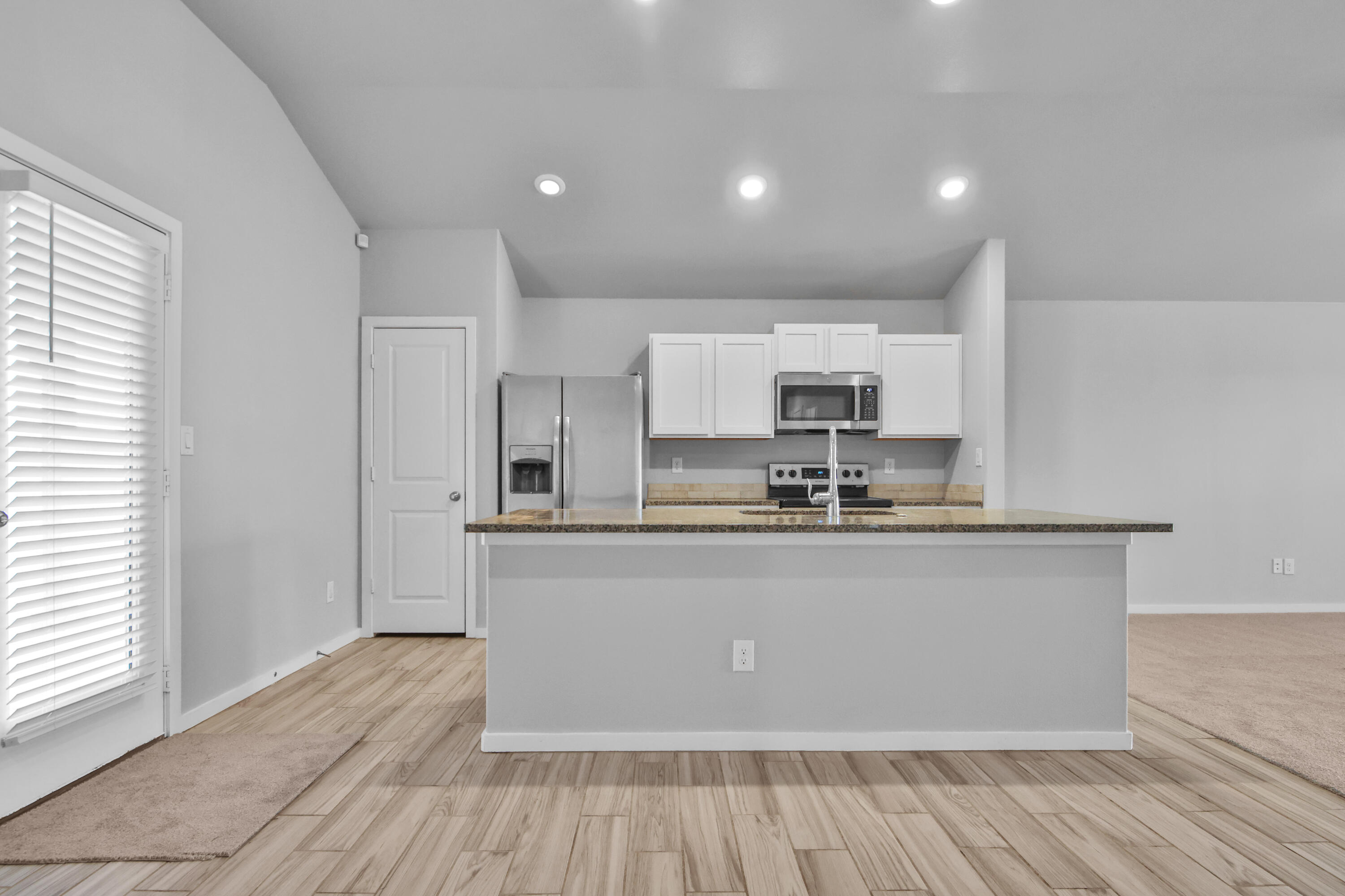 7526 104th Street Lubbock, TX 79424 - Photo 7 of 28 a large kitchen with stainless steel appliances granite countertop a stove a sink and a refrigerator