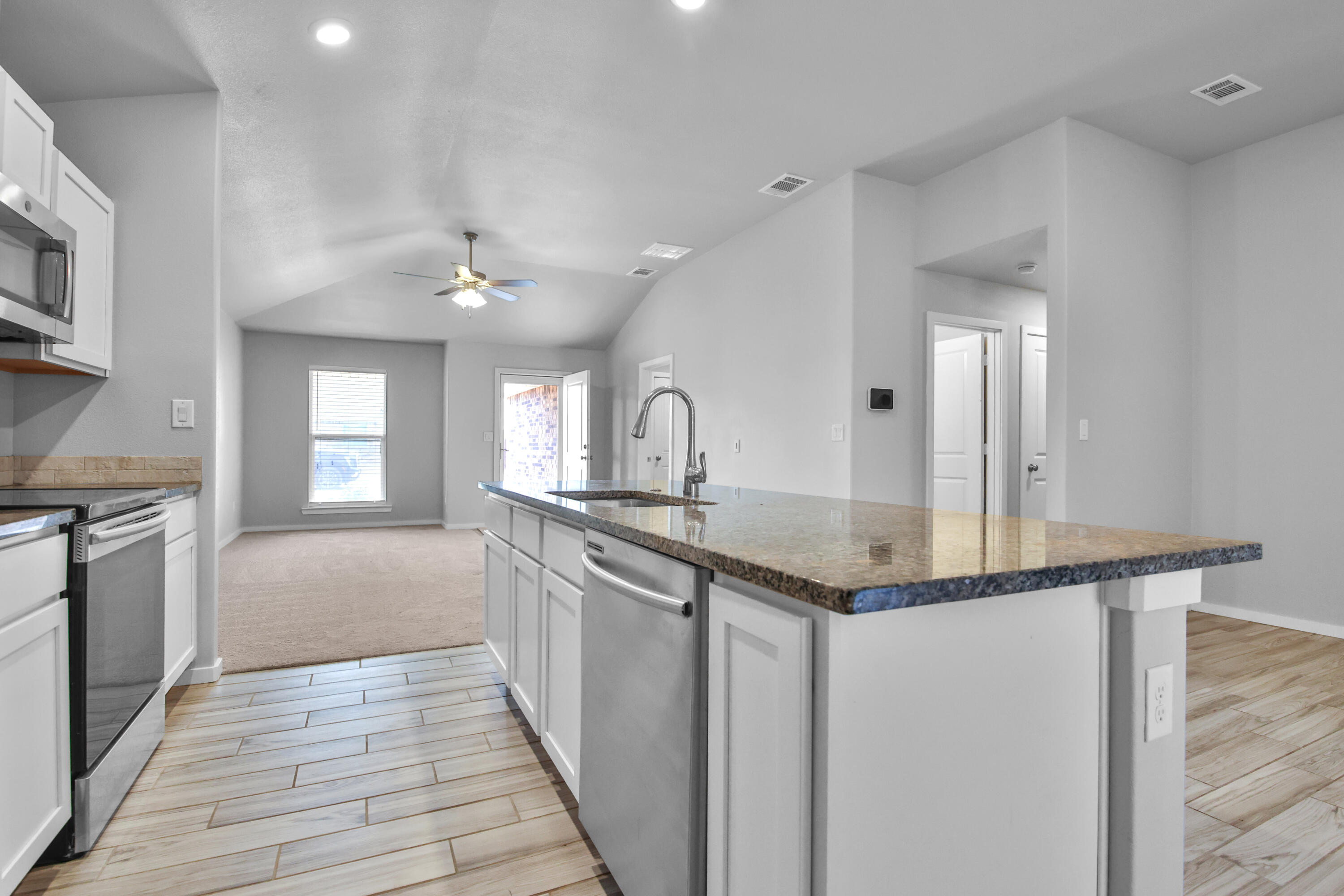 7526 104th Street Lubbock, TX 79424 - Photo 9 of 28 a kitchen with granite countertop a sink cabinets and stainless steel appliances