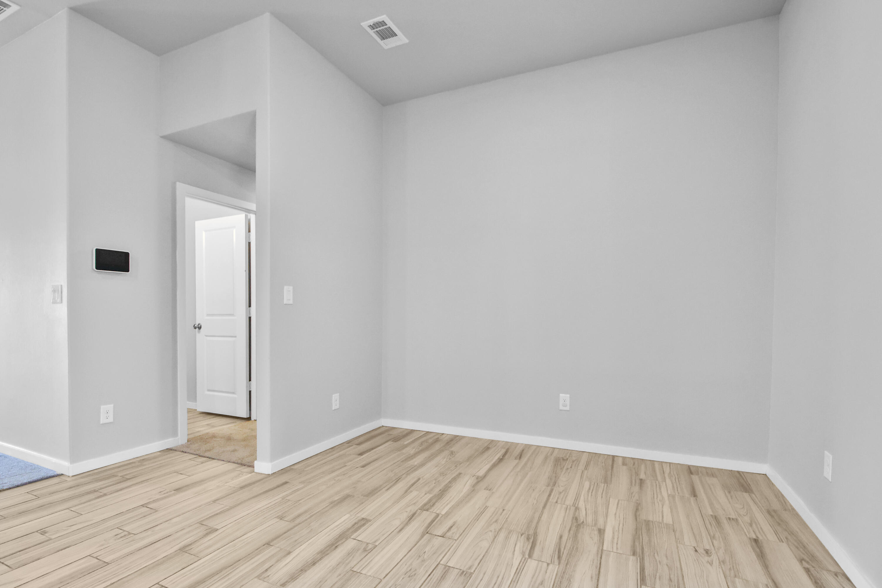 7526 104th Street Lubbock, TX 79424 - Photo 10 of 28 a view of an empty room with wooden floor and a window