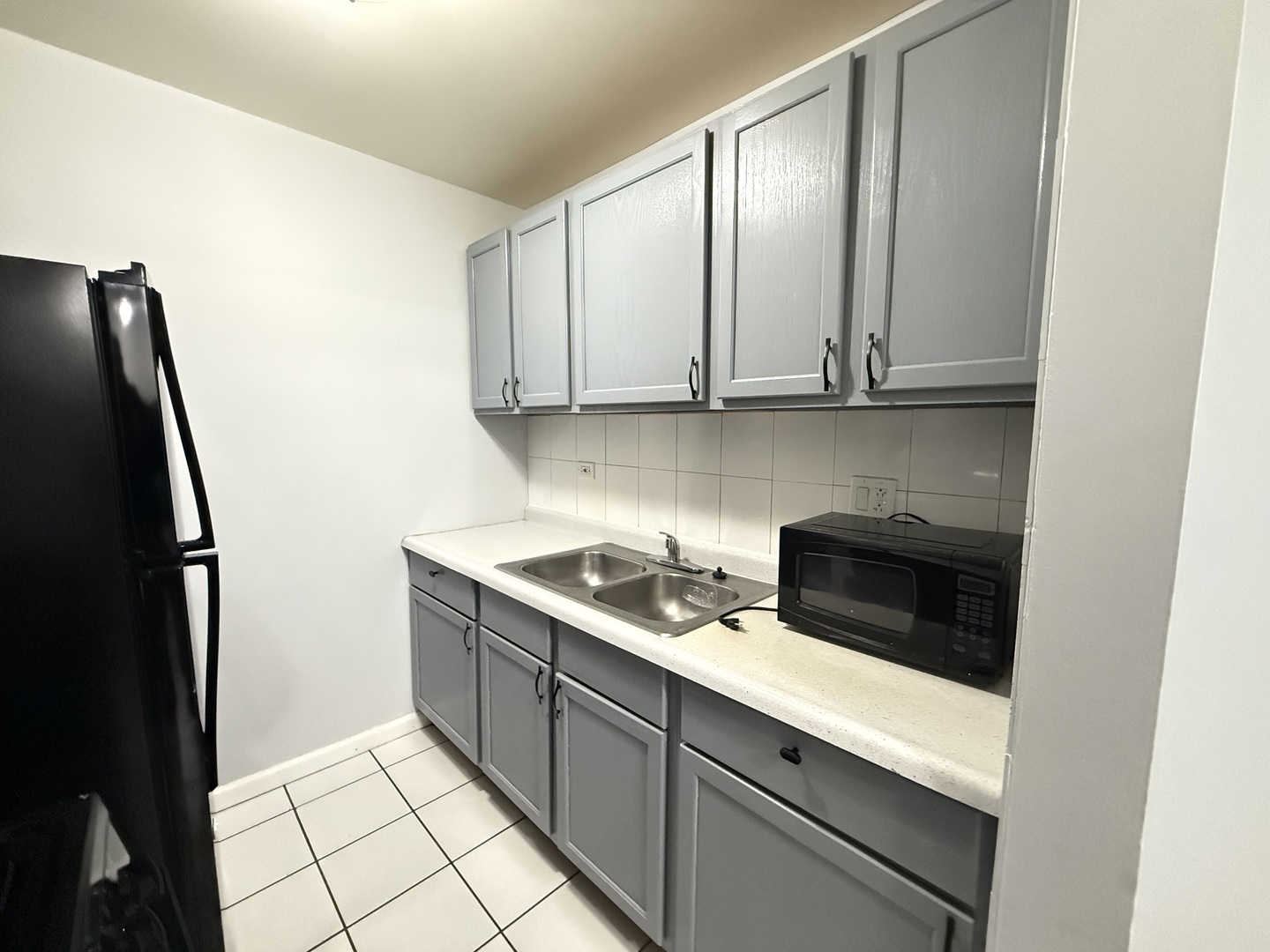 600 Mesa Drive, Unit 104 Hoffman Estates, IL 60169 - Photo 11 of 12 a kitchen with a sink and a refrigerator