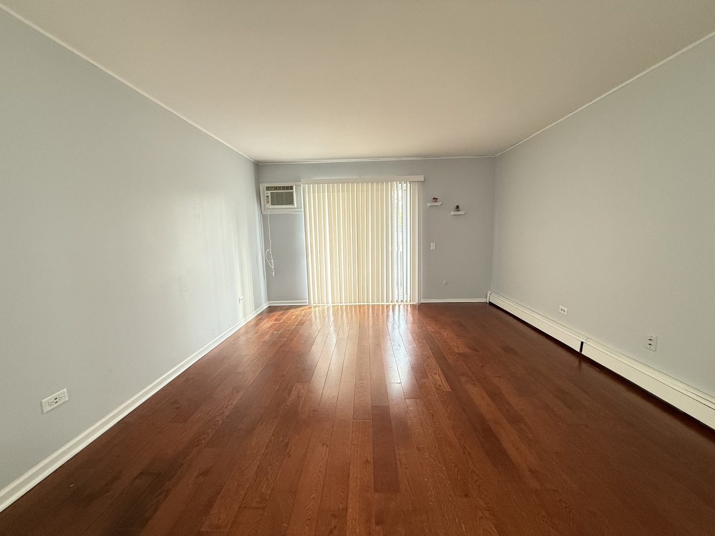 600 Mesa Drive, Unit 104 Hoffman Estates, IL 60169 - Photo 2 of 12 an empty room with wooden floor and windows