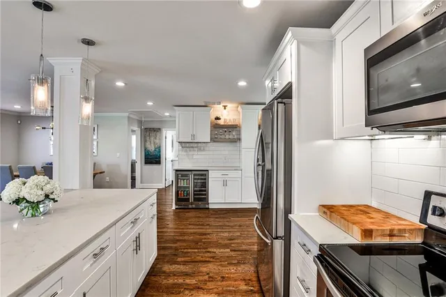 a kitchen with stainless steel appliances kitchen island granite countertop a refrigerator and a stove top oven