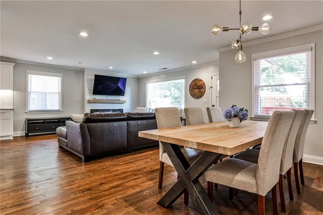 a living room with furniture a large window and a dining table