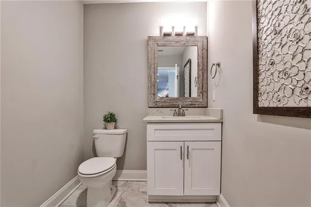 a bathroom with a toilet a sink and mirror