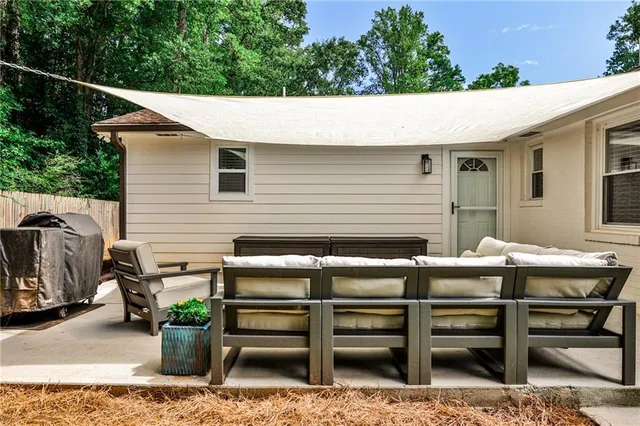 a backyard of a house with wooden table and chairs
