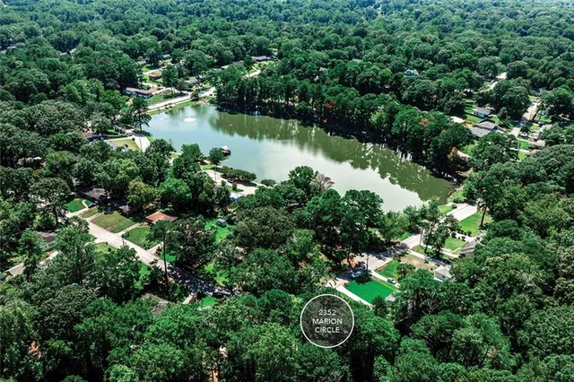 an aerial view of a house with outdoor space and trees all around