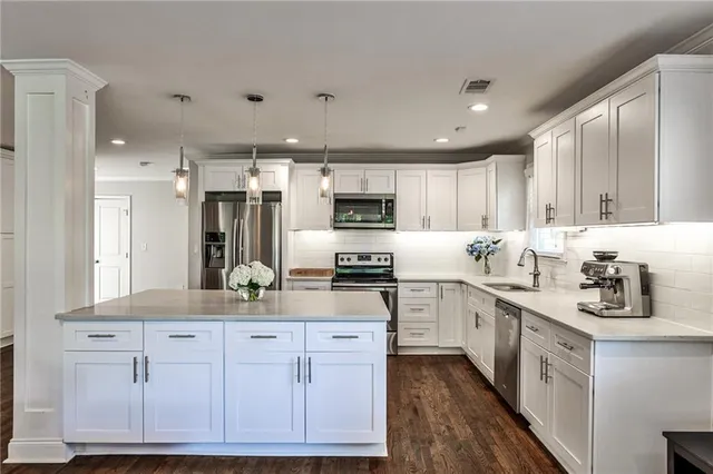 a kitchen with stainless steel appliances granite countertop a sink and cabinets