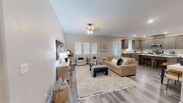 a living room with furniture kitchen view and a window