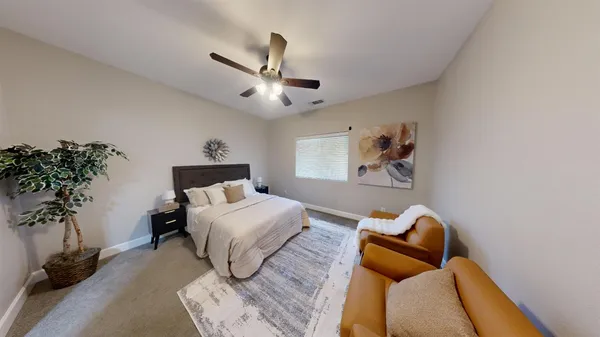 a spacious bedroom with a bed and wooden floor