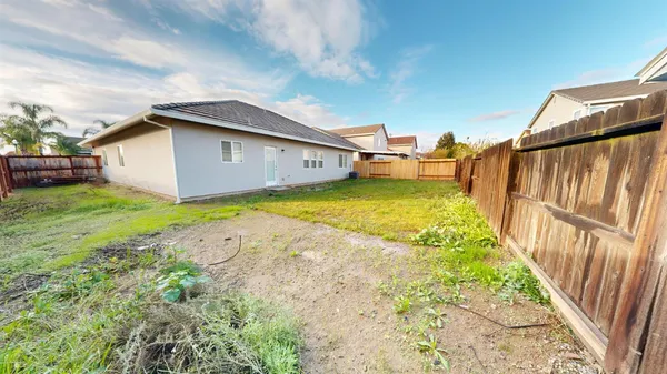a backyard of a house with table and chairs