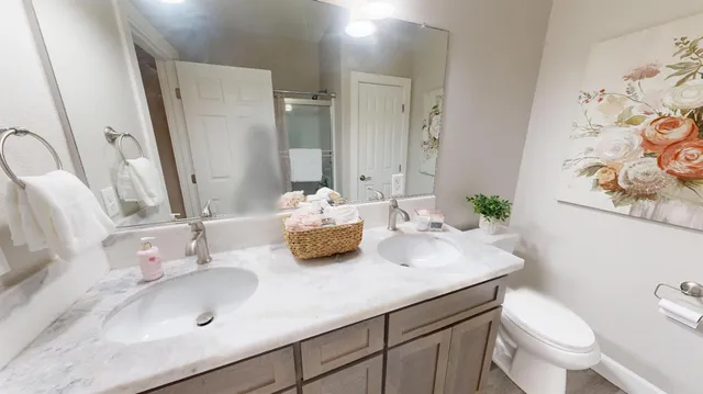 a bathroom with a granite countertop toilet sink and mirror