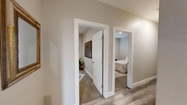 a view of a hallway with a livingroom and hardwood floor