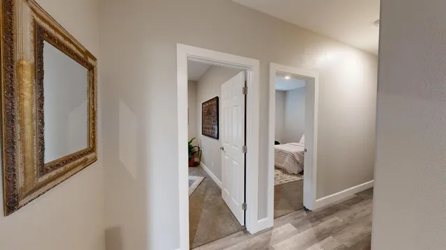 a view of a hallway with a livingroom and hardwood floor