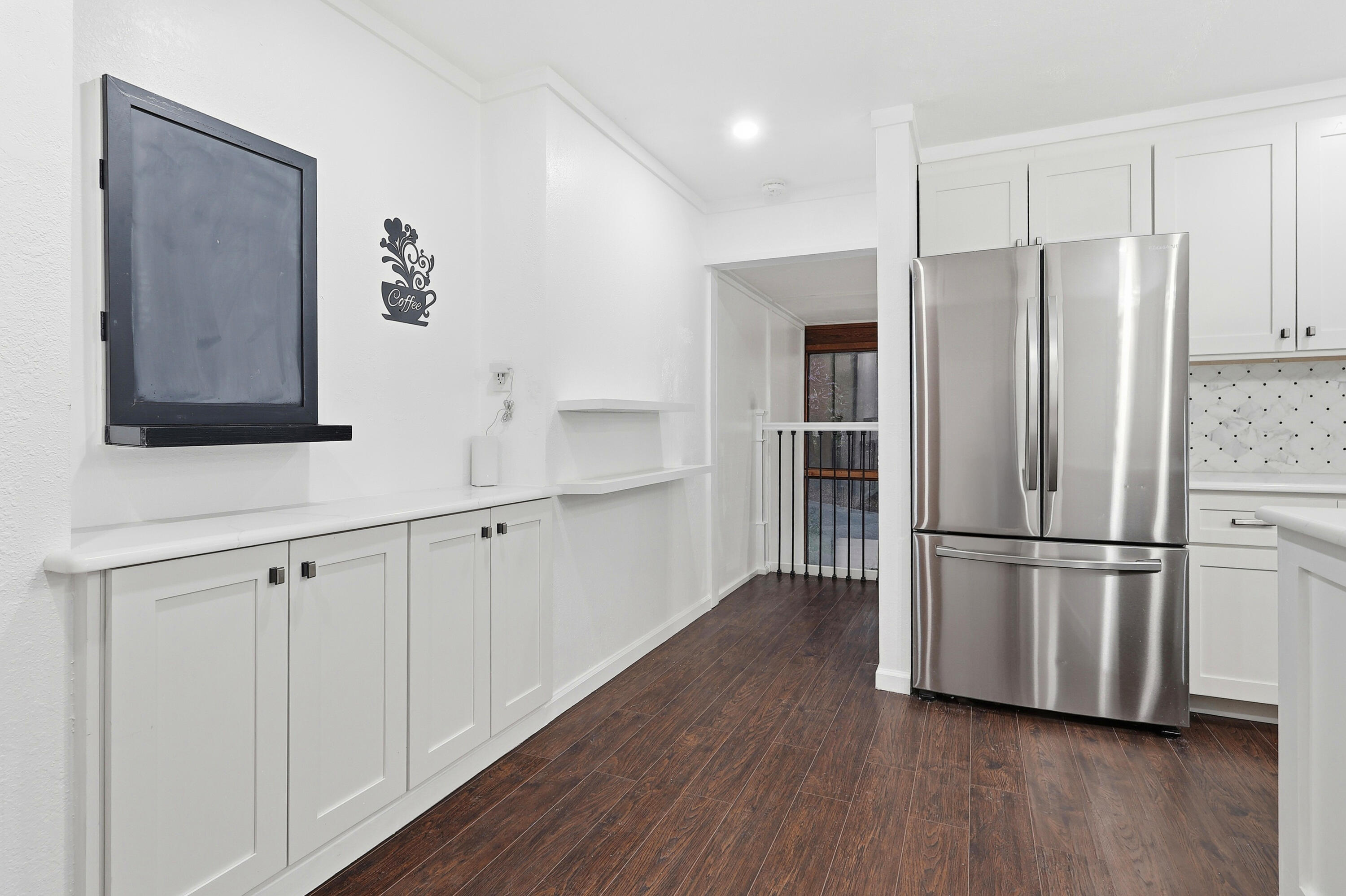 4578 Riley Road Milton, FL 32583 - Photo 16 of 55 a kitchen with stainless steel appliances white cabinets and wooden floor