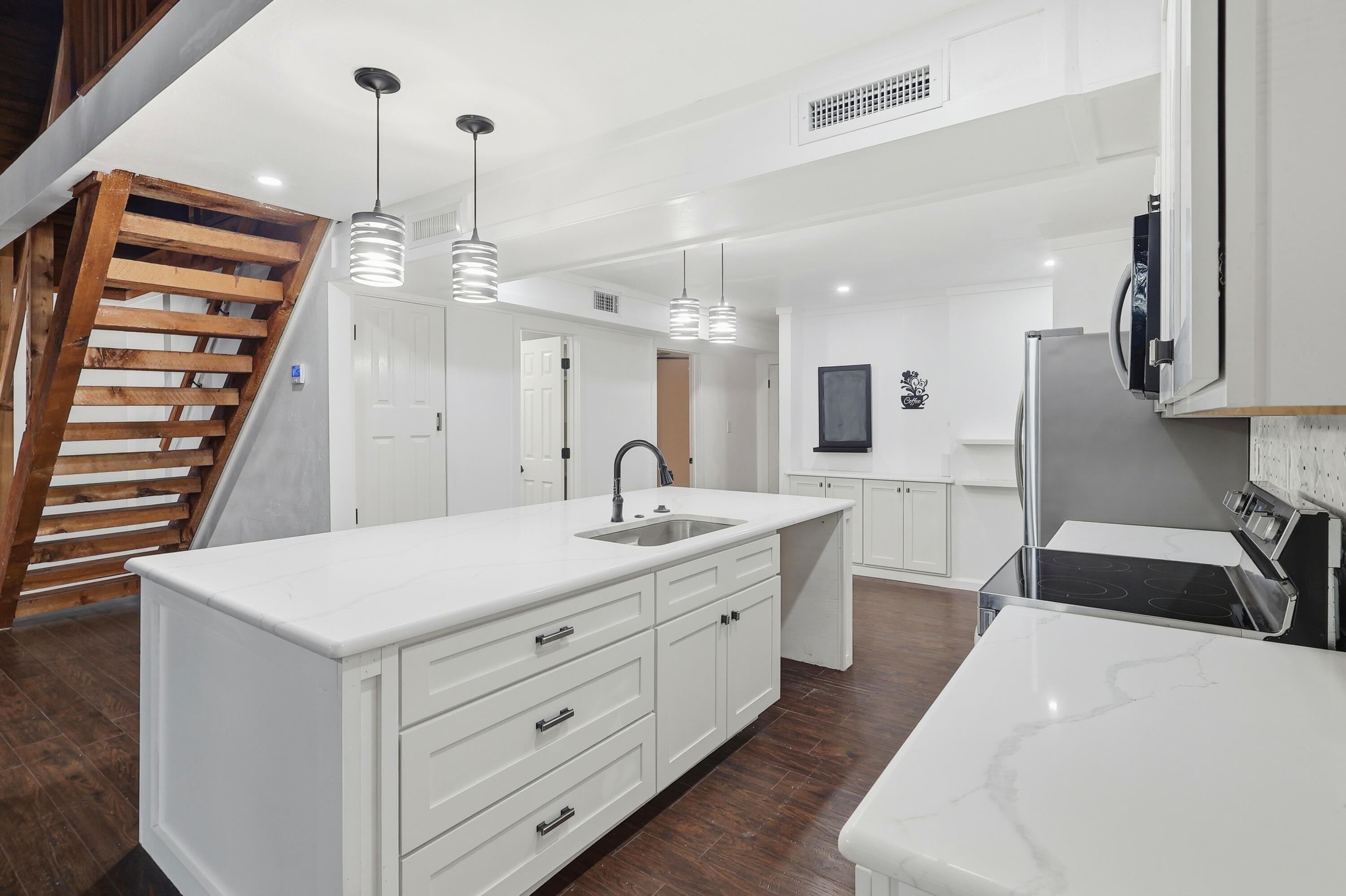 4578 Riley Road Milton, FL 32583 - Photo 19 of 55 a large white kitchen with a large island oven a sink stainless steel appliances and cabinets