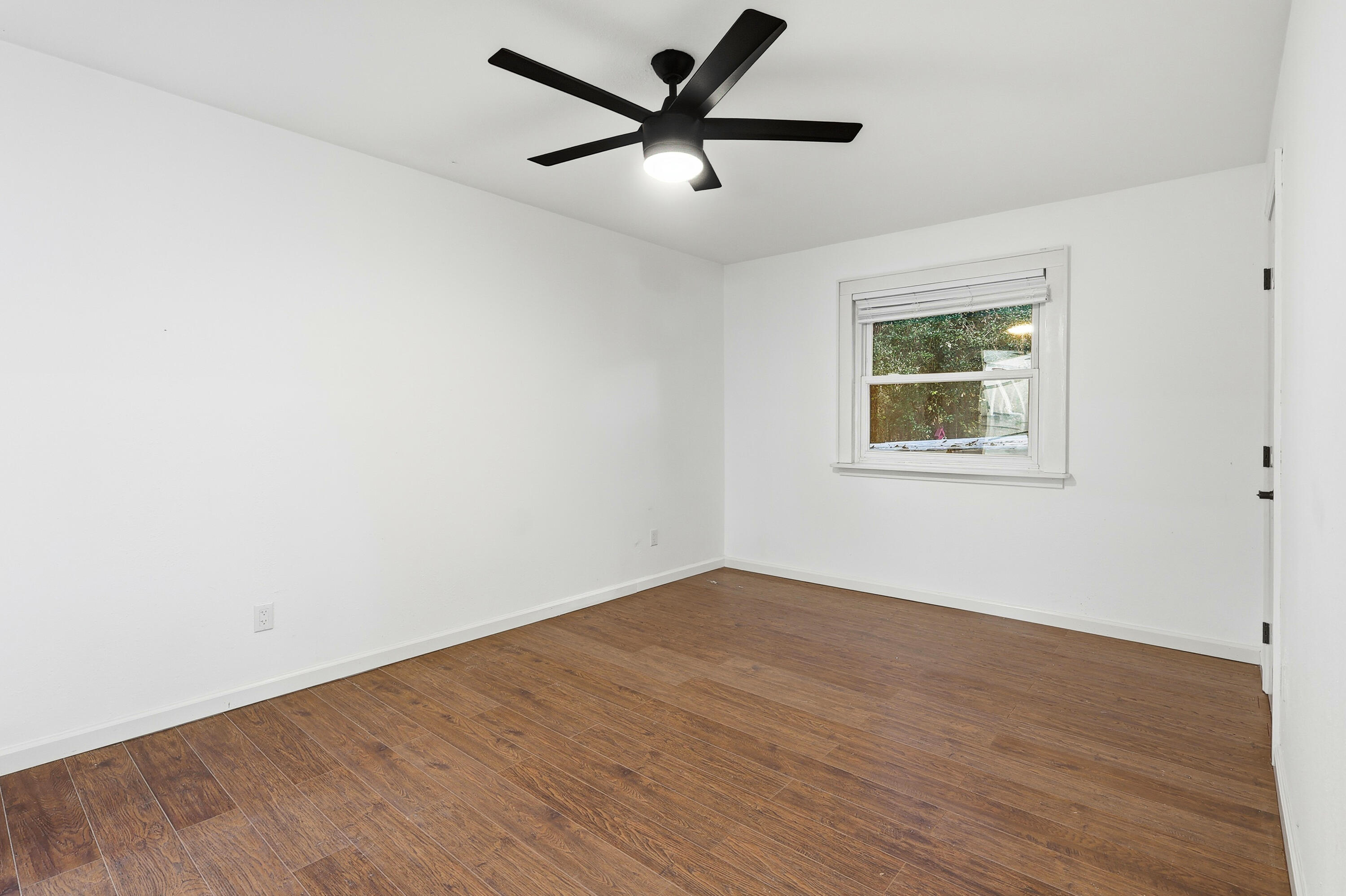 4578 Riley Road Milton, FL 32583 - Photo 30 of 55 an empty room with wooden floor and windows