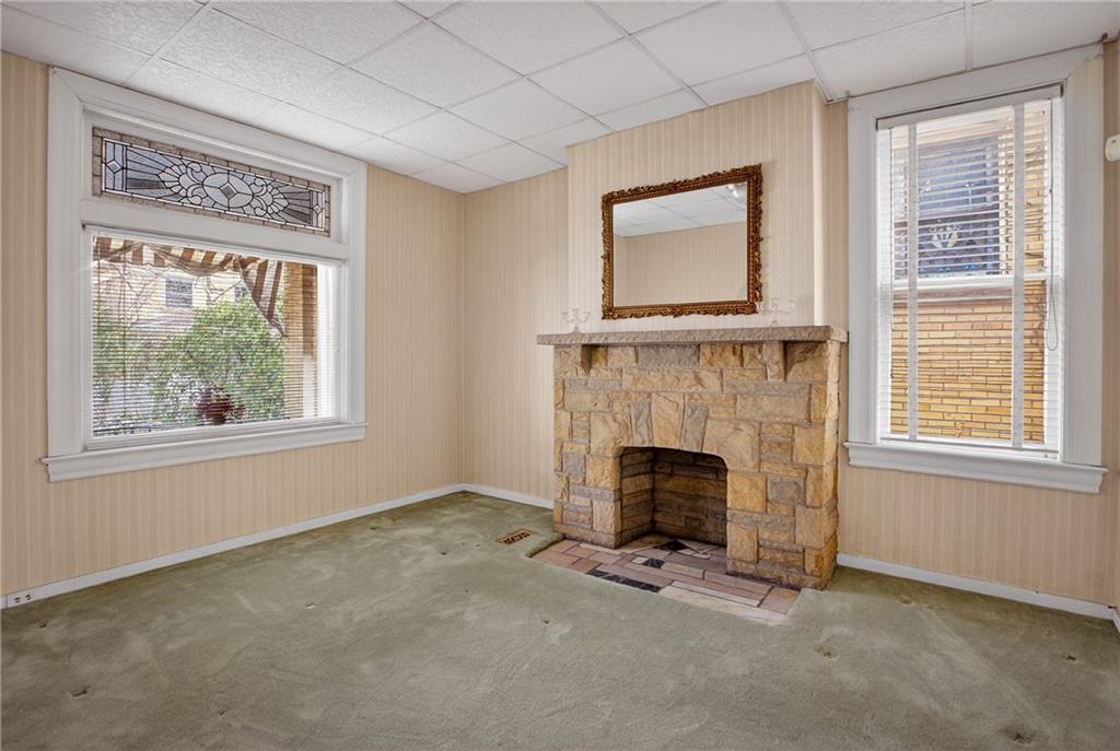 417 Zara Street Pittsburgh, PA 15210 - Photo 12 of 47 an empty room with windows fireplace and cabinet