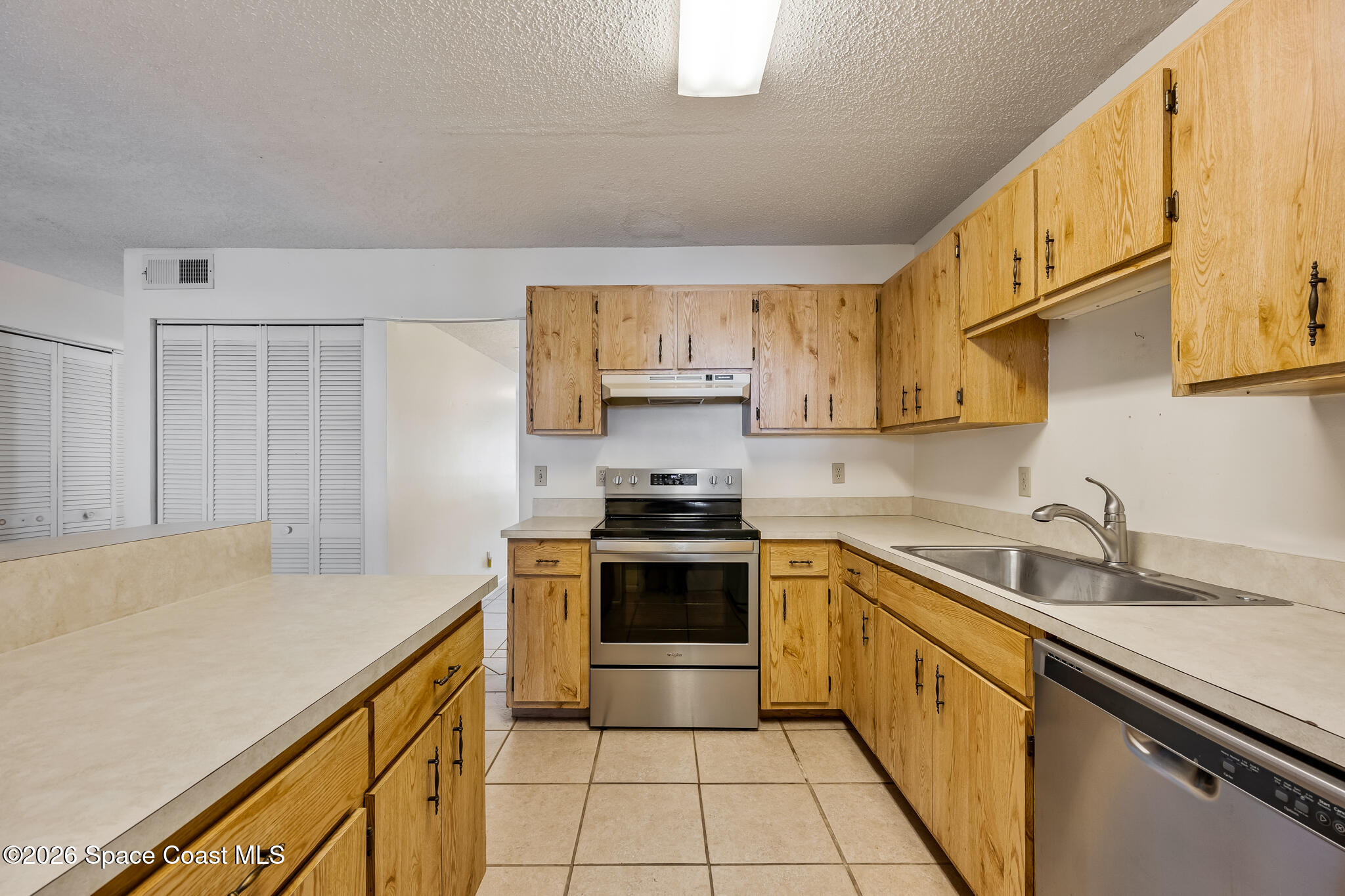 2016 Manor Drive Northeast Palm Bay, FL 32905 - Photo 6 of 29 a kitchen with stainless steel appliances a stove sink and cabinets