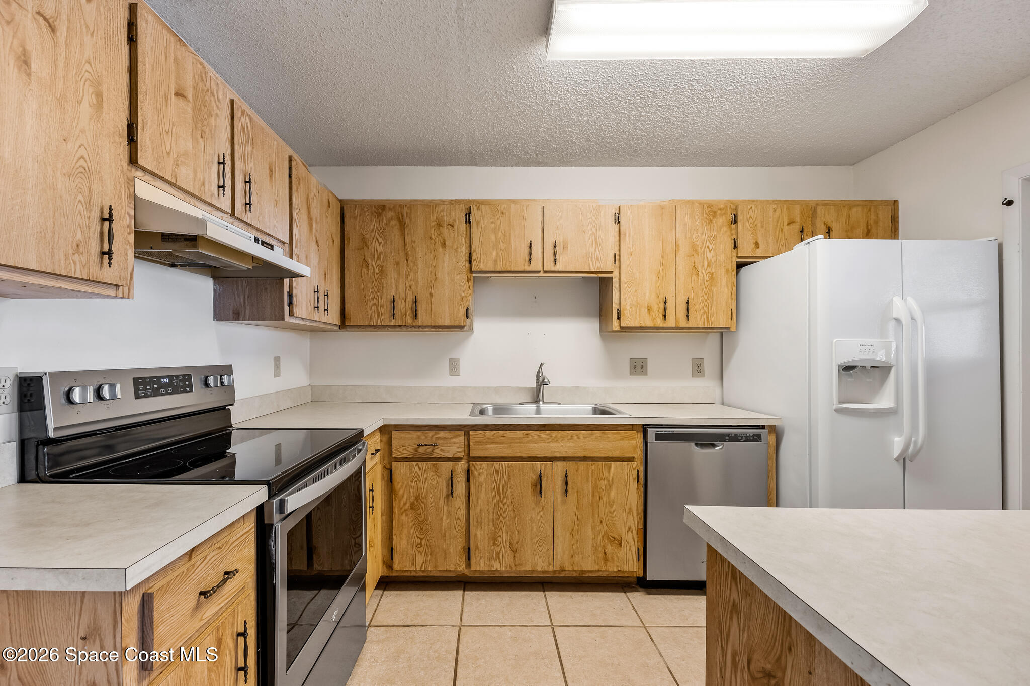 2016 Manor Drive Northeast Palm Bay, FL 32905 - Photo 8 of 29 a kitchen with a stove a sink and a refrigerator