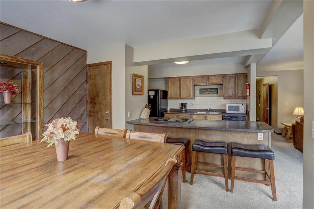 325 Four Oclock Road, Unit C203 Breckenridge, CO 80424 - Photo 23 of 35 a kitchen with stainless steel appliances granite countertop a stove top oven a sink a dining table and chairs