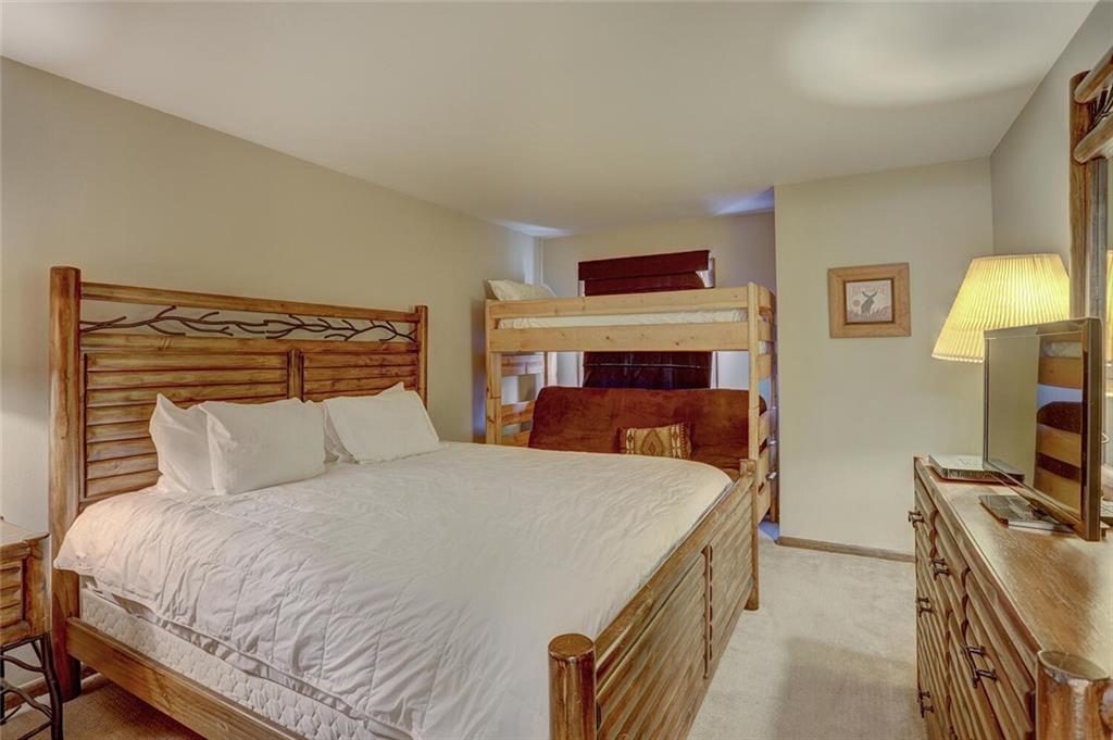 325 Four Oclock Road, Unit C203 Breckenridge, CO 80424 - Photo 26 of 35 a bedroom with a bed and a flat screen tv