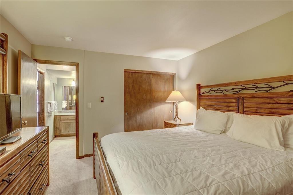 325 Four Oclock Road, Unit C203 Breckenridge, CO 80424 - Photo 28 of 35 a bedroom with a bed and a chandelier