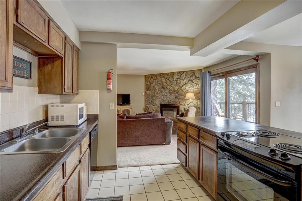 325 Four Oclock Road, Unit C203 Breckenridge, CO 80424 - Photo 6 of 35 a kitchen with a sink stove top oven and granite counter top