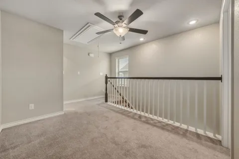 an empty room with ceiling fan and window