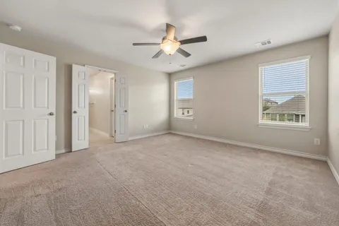 an empty room with fan and windows