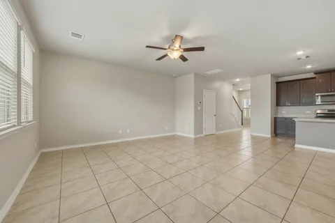 an empty room with windows and fan
