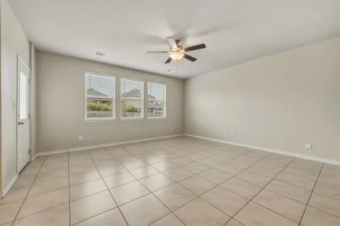 an empty room with windows and fan