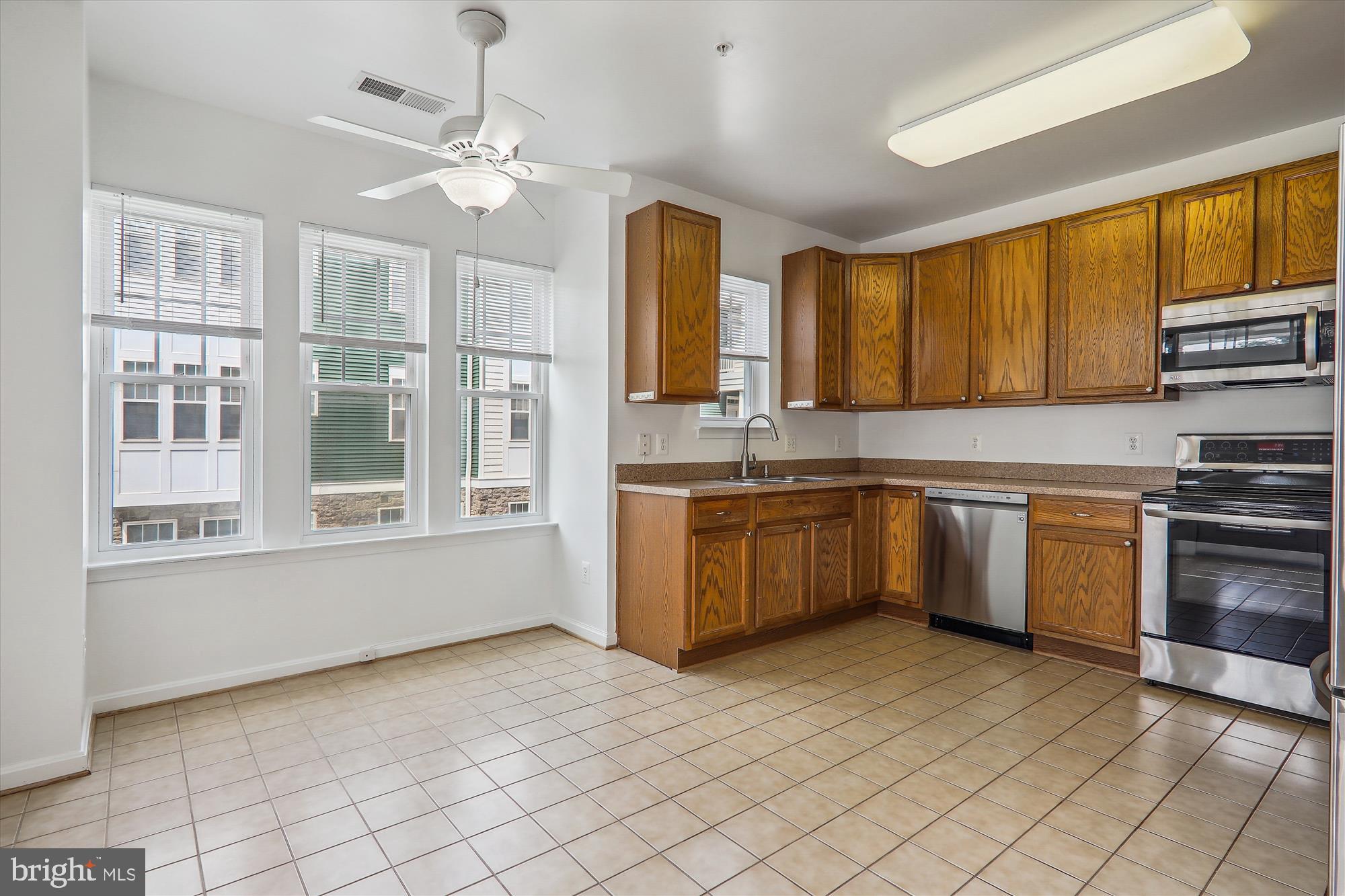 13851 Belle Chasse Boulevard, Unit 213 Laurel, MD 20707 - Photo 3 of 54 a kitchen with stainless steel appliances granite countertop a stove a sink dishwasher and a refrigerator