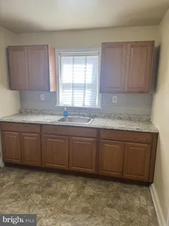 a kitchen with granite countertop a sink and cabinets