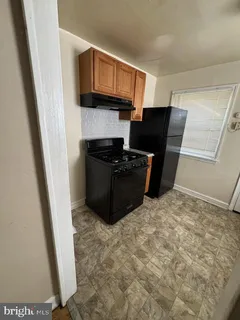a kitchen with cabinets and a refrigerator