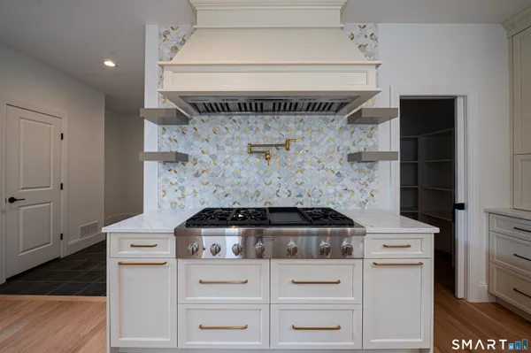 a stove top oven sitting inside of a kitchen
