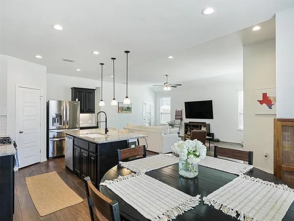 a living room with stainless steel appliances furniture a rug and a view
