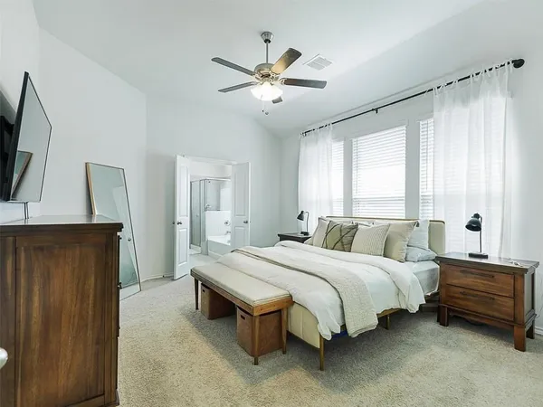 a bedroom with a bed a window and dresser