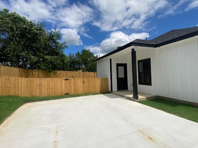 116 Field Street Luling, TX 78648 - Photo 16 of 33 A private backyard oasis features a fresh concrete pad, lush grass, and secure wooden fencing.