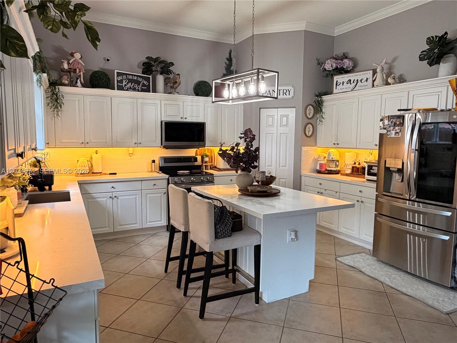 2116 Northeast 38th Road, Unit 2116 Homestead, FL 33033 - Photo 28 of 31 a kitchen with stainless steel appliances a stove a sink and a refrigerator