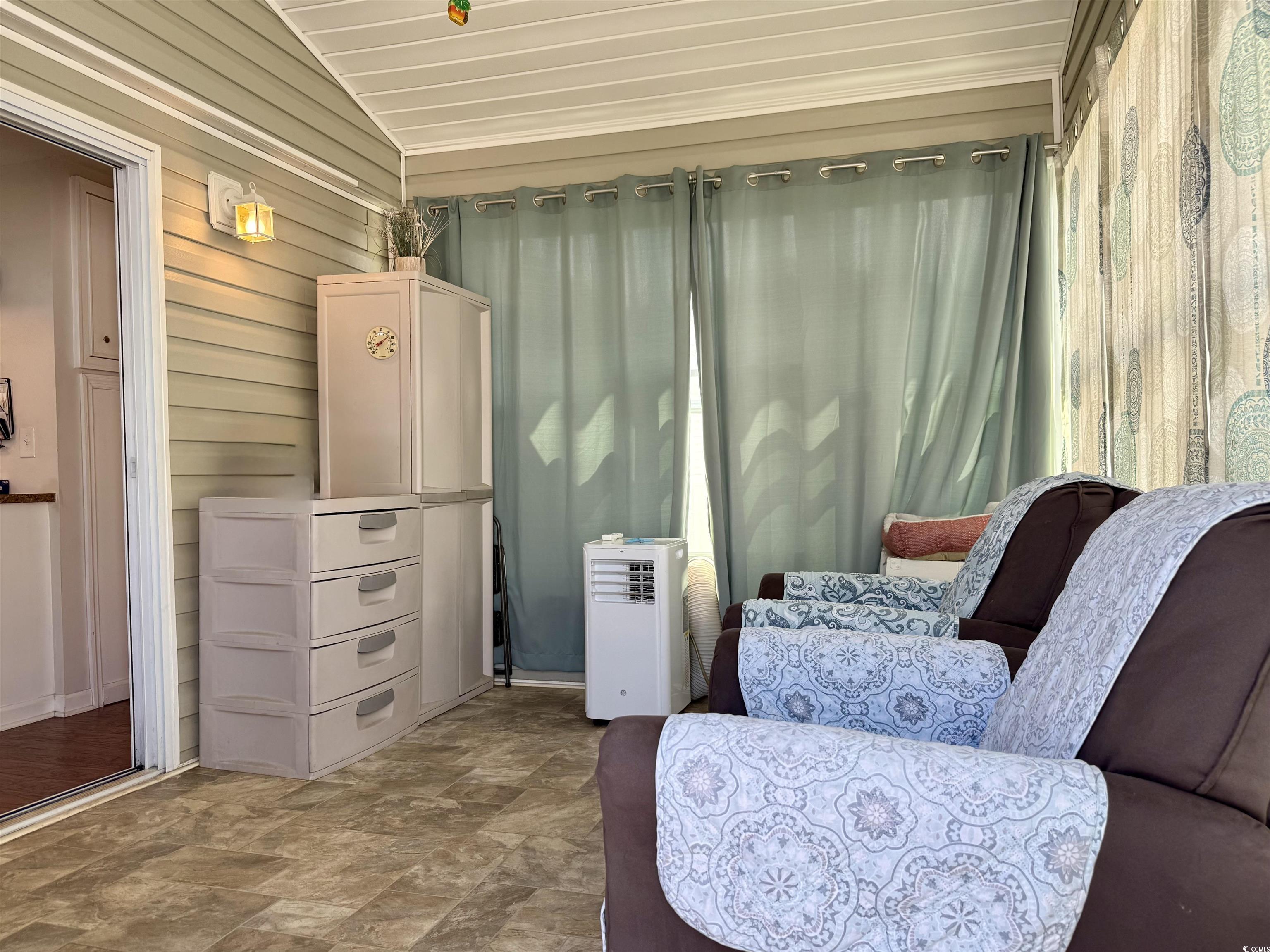 1760 Egret Surfside Beach, SC 29575 - Photo 2 of 29 Sitting room featuring lofted ceiling, stone finish floors, and wood walls