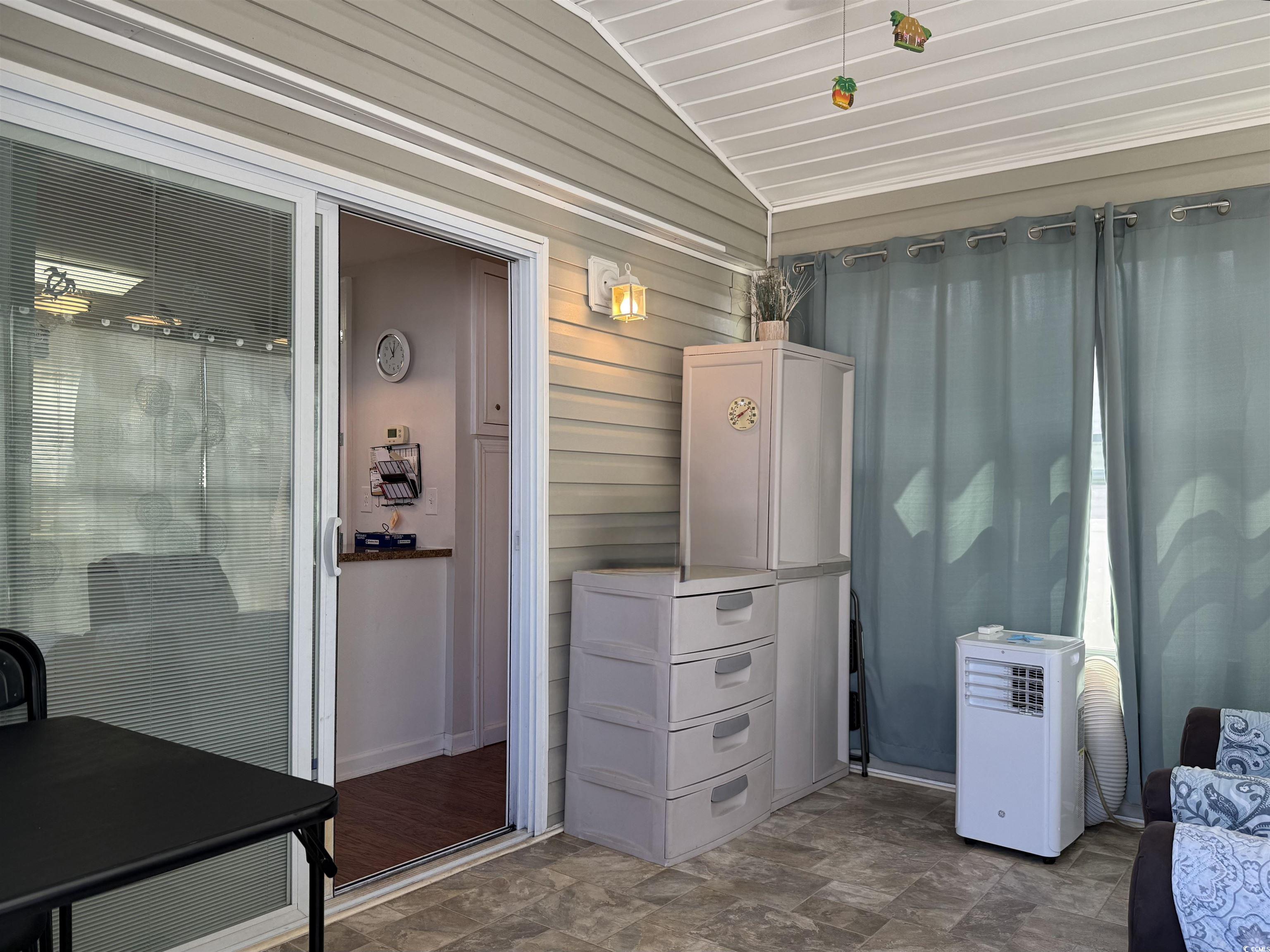 1760 Egret Surfside Beach, SC 29575 - Photo 3 of 29 Miscellaneous room featuring lofted ceiling, wooden walls, and stone finish floors
