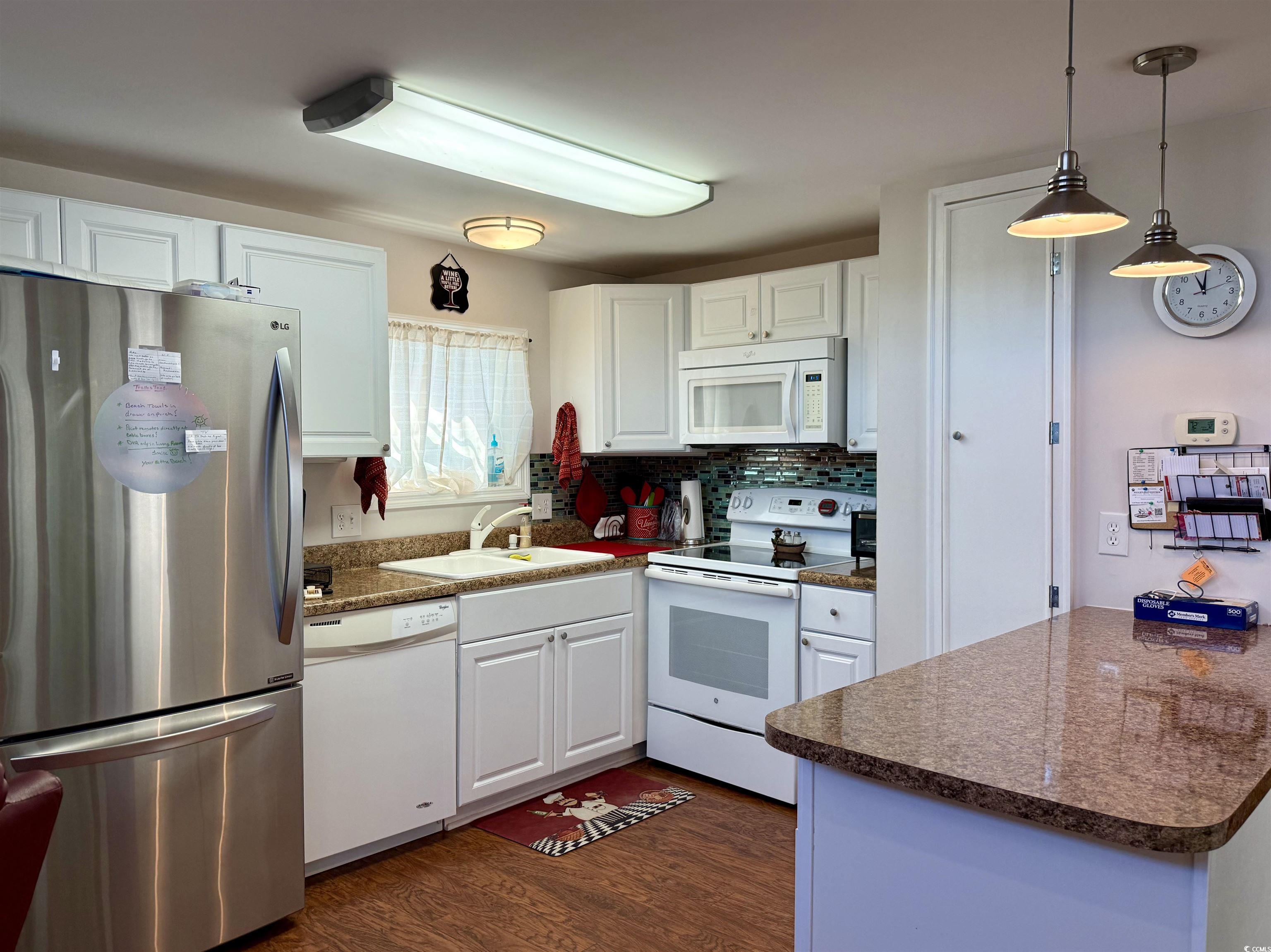 1760 Egret Surfside Beach, SC 29575 - Photo 6 of 29 Kitchen with white appliances, dark wood finished floors, white cabinetry, and dark countertops