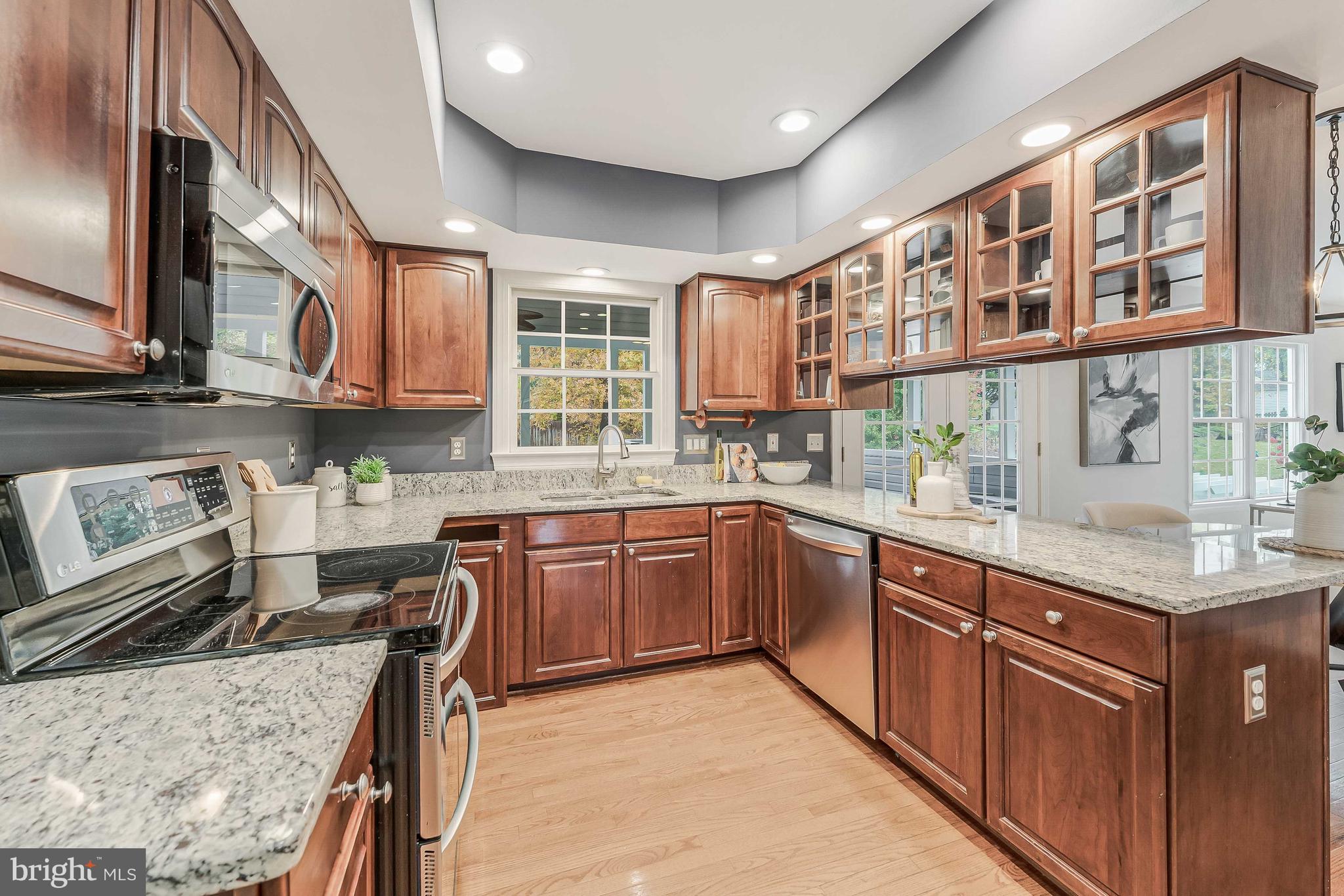 8926 Jameson Street Lorton, VA 22079 - Photo 12 of 32 a kitchen with stainless steel appliances granite countertop wooden cabinets a stove top oven a sink and dishwasher