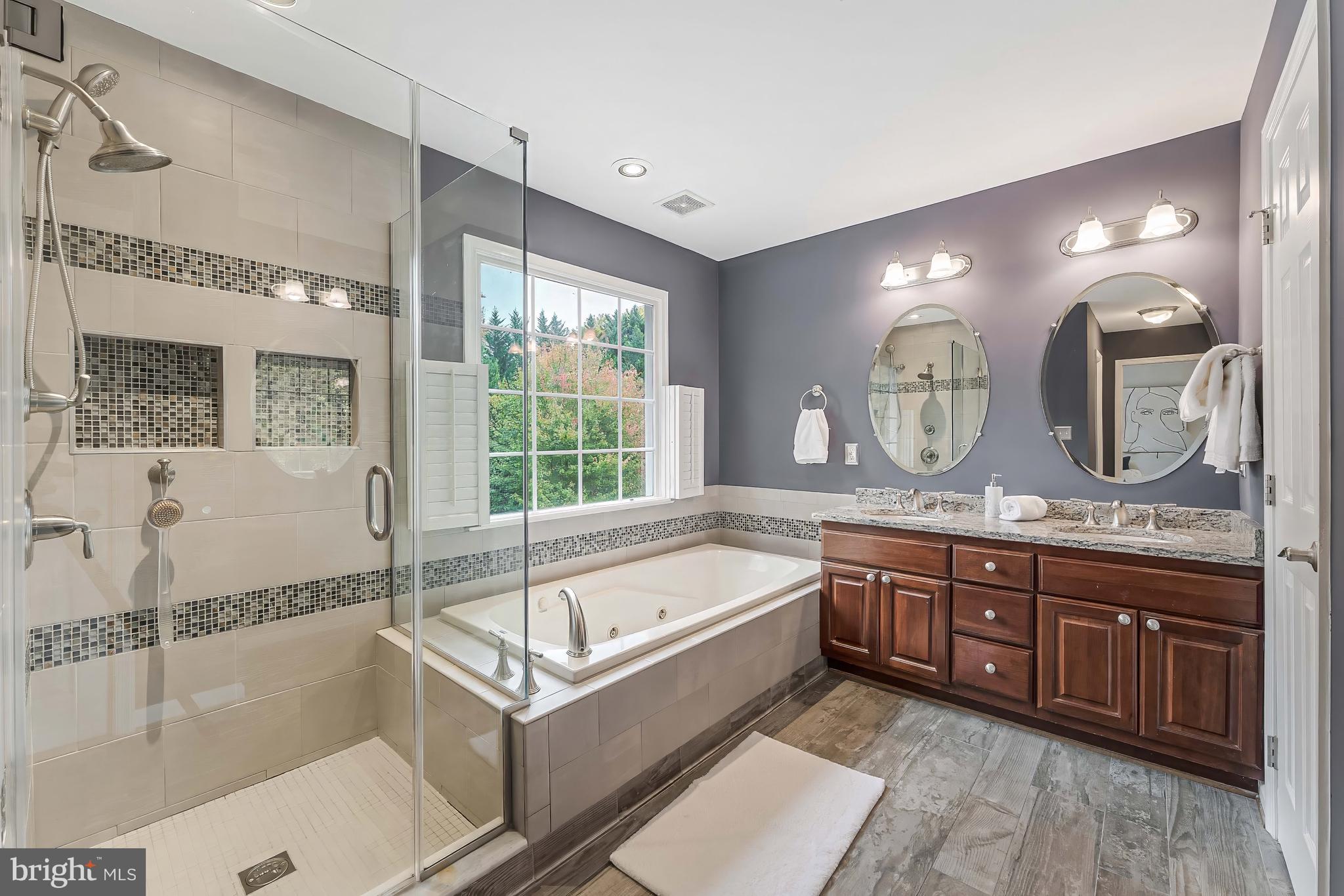 8926 Jameson Street Lorton, VA 22079 - Photo 19 of 32 a spacious bathroom with a granite countertop tub sink and mirror